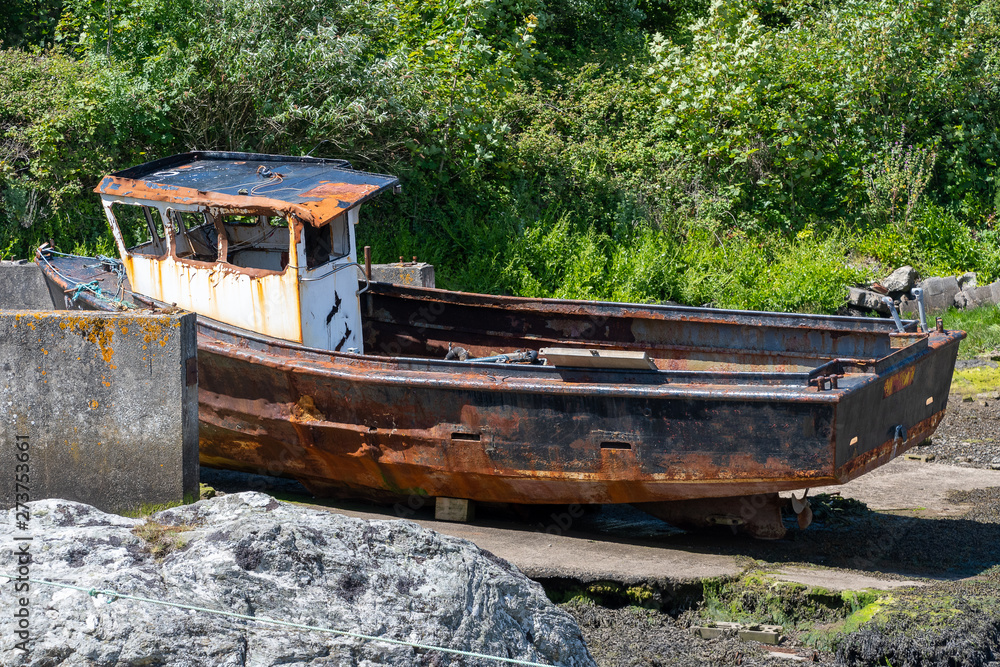 Rusting derelict boat left on a beach Rusting derelict boat left on a beach