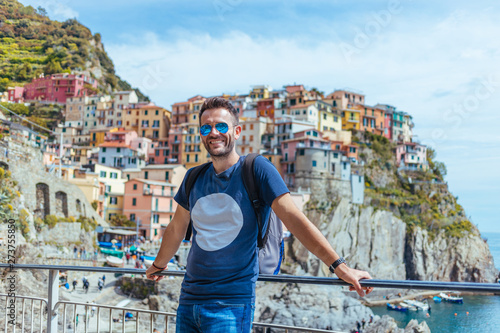 Young man enjoying the view of Manarola in the UNESCO World Heritage Site Cinque Terre, Liguria, Italy