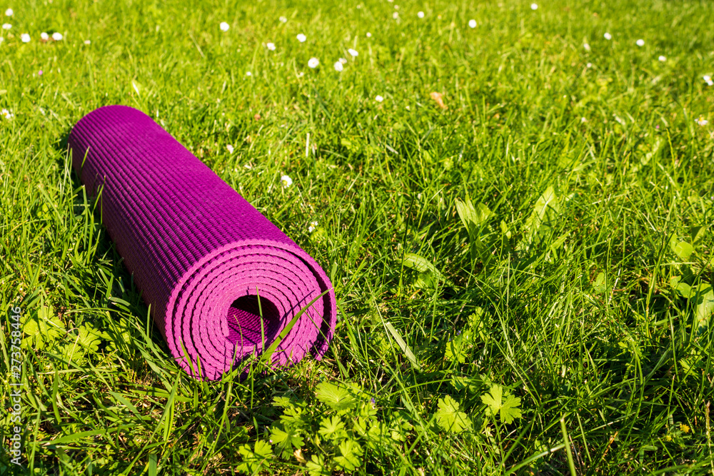 Drijvende kracht Optimaal Registratie Rolled Yoga mat on green grass with sunlight, close up and front view Stock  Photo | Adobe Stock