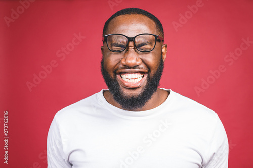 Portrait of African American man laughing isilated over red. photo