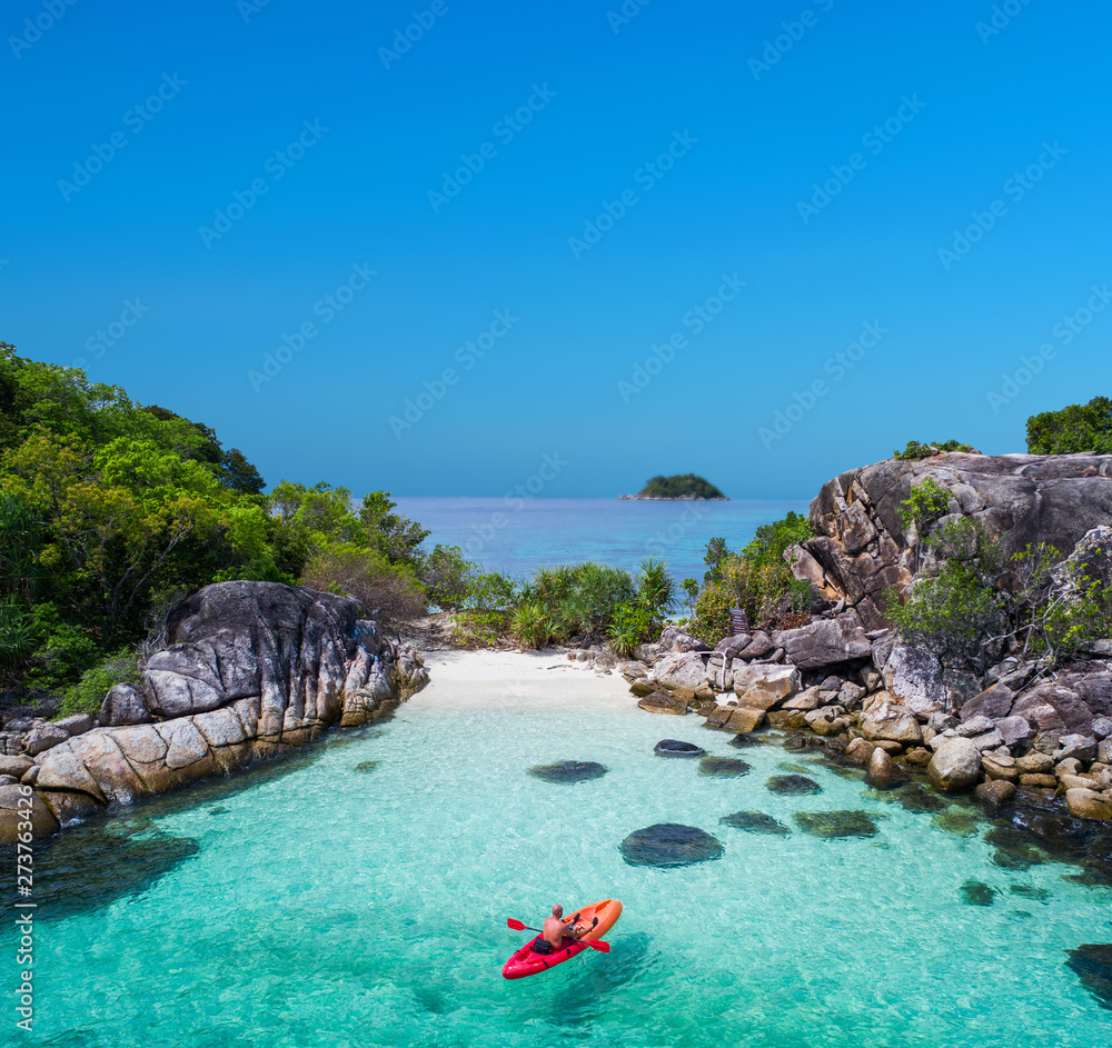 Aerial drone view of in kayak in crystal clear lagoon sea water during summer day near Koh Lipe island in Thailand. Travel tropical island holiday concept