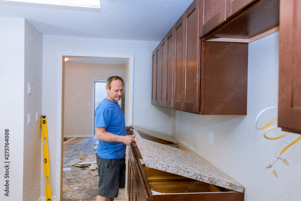 Carpenter installing c counter top in a kitchen