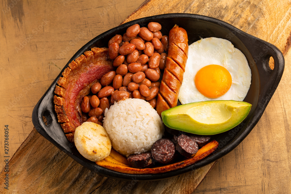 Abandonado Competencia Distribuir Bandeja paisa, typical dish at the Antioqueña region of Colombia. It  consists of chicharrón (fried pork belly), black pudding, sausage, arepa,  beans, fried plantain, avocado egg, and rice foto de Stock 