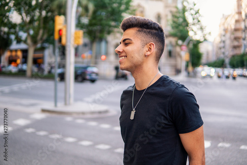 Young fashionable handsome man on the street of modern city. He looks happy and smiling © Igor Kardasov