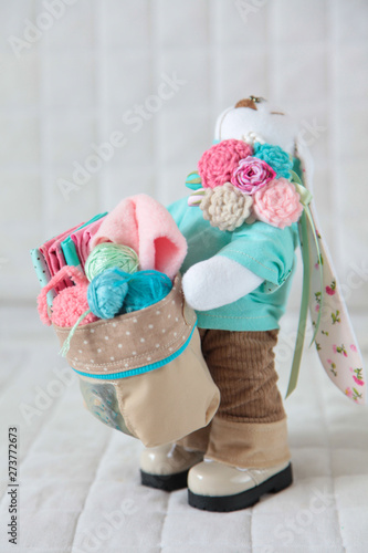 Handmade toy. Doll of textiles. Rabbit with basket of needlework sewn by hand.