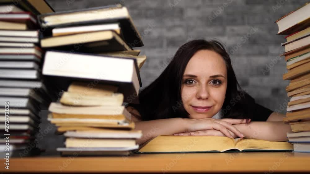 Woman student boring reading book at library with a lot of books in university. Woman student boring reading book at library with a lot of books in university.