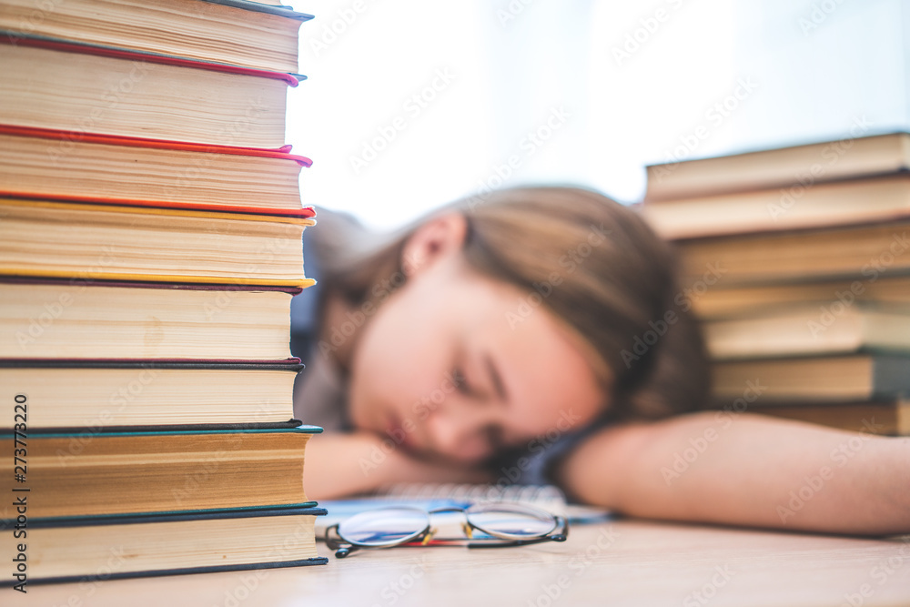 Stressed college student tired of hard learning with books in exams tests preparation, overwhelmed high school teen girl exhausted with difficult studies or too much homework, cram concept Stressed college student tired of hard learning with books in exams tests preparation, overwhelmed high school teen girl exhausted with difficult studies or too much homework, cram concept