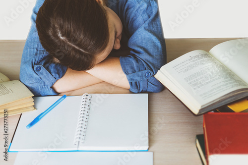 Stressed college student tired of hard learning with books in exams tests preparation, overwhelmed high school teen girl exhausted with difficult studies or too much homework, cram concept