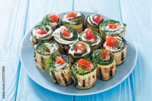 Zucchini rolls with cream cheese , tomatoes and dill