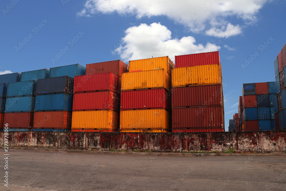Shipping Containers placed as layered in the storage facility on blue sky background. Shipping Containers placed as layered in the storage facility on blue sky background.