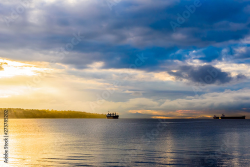 Cargo ships at cloudy sunset in bay near Vancouver  BC  Canada.