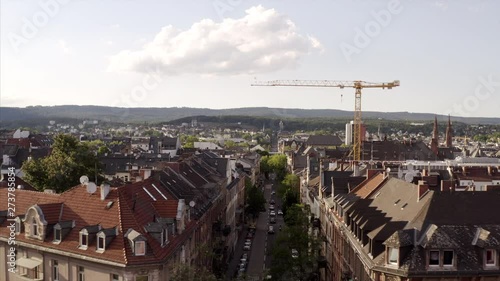 Flying through the Oranienstrasse in Wiesbaden, Germany on a sunny day. The drone is flying over the roofs and birds are flying into the sky. photo