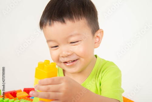 Little boy toddler playing plastic brick block colorful with happy