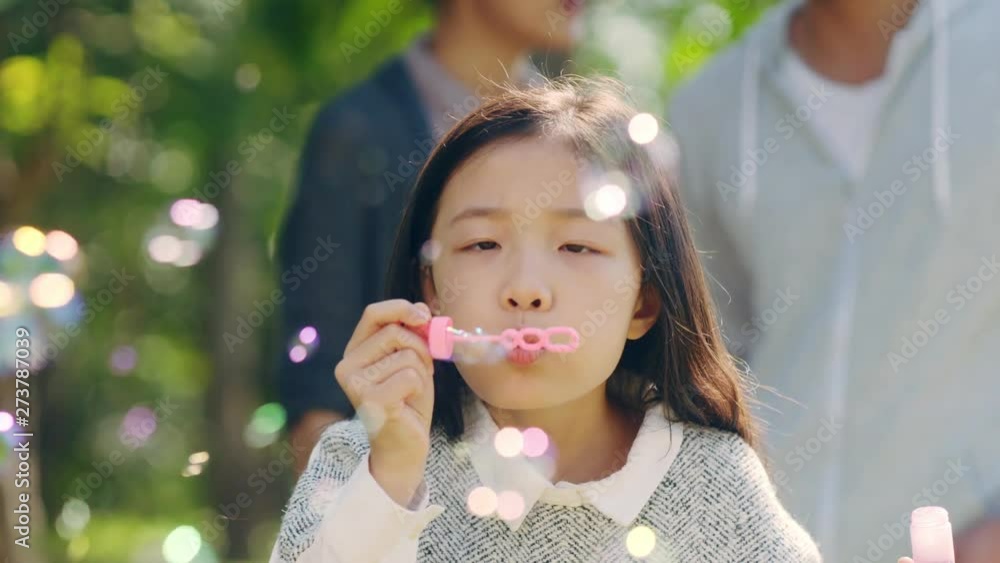 beautiful little asian girl blowing bubbles in park beautiful little asian girl blowing bubbles in park