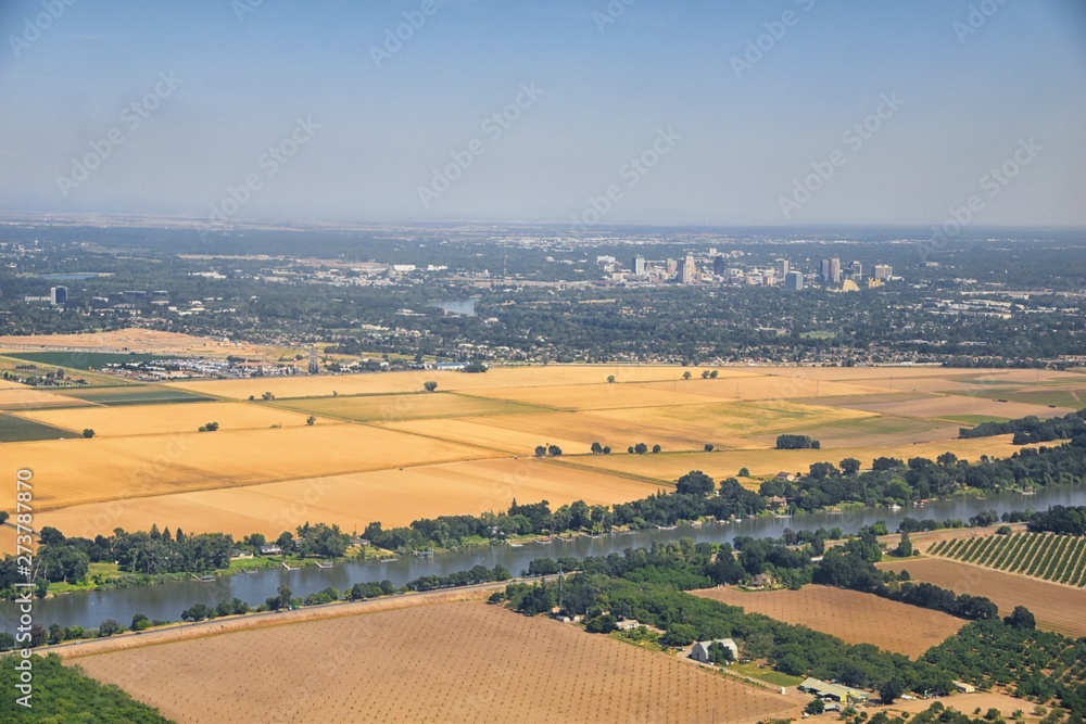 Sacramento downtown aerial from airplane, including view of rural surrounding farming and agricultural fields, river and landscape. California, United States.