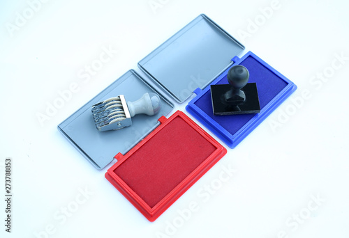 Rubber stamper and Red - Blue Ink cartridges on white background.