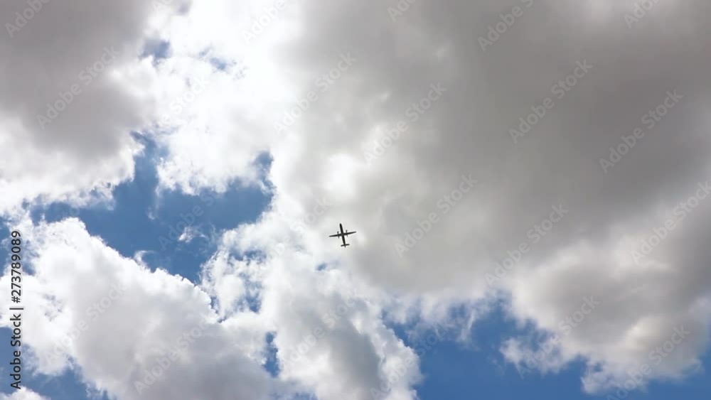 Panning shot of airplane near an airport, taking off and flying through blue skies with sunshine and clouds. Panning shot of airplane near an airport, taking off and flying through blue skies with sunshine and clouds.