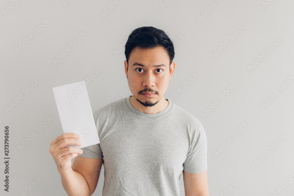 Man is reading the white mail message or the bill. Man is reading the white mail message or the bill.