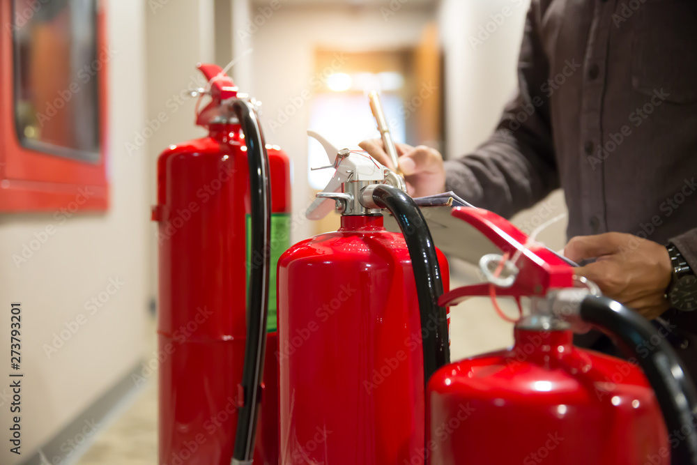 Red Fire extinguishers in the building,Engineers are checking fire extinguishers.