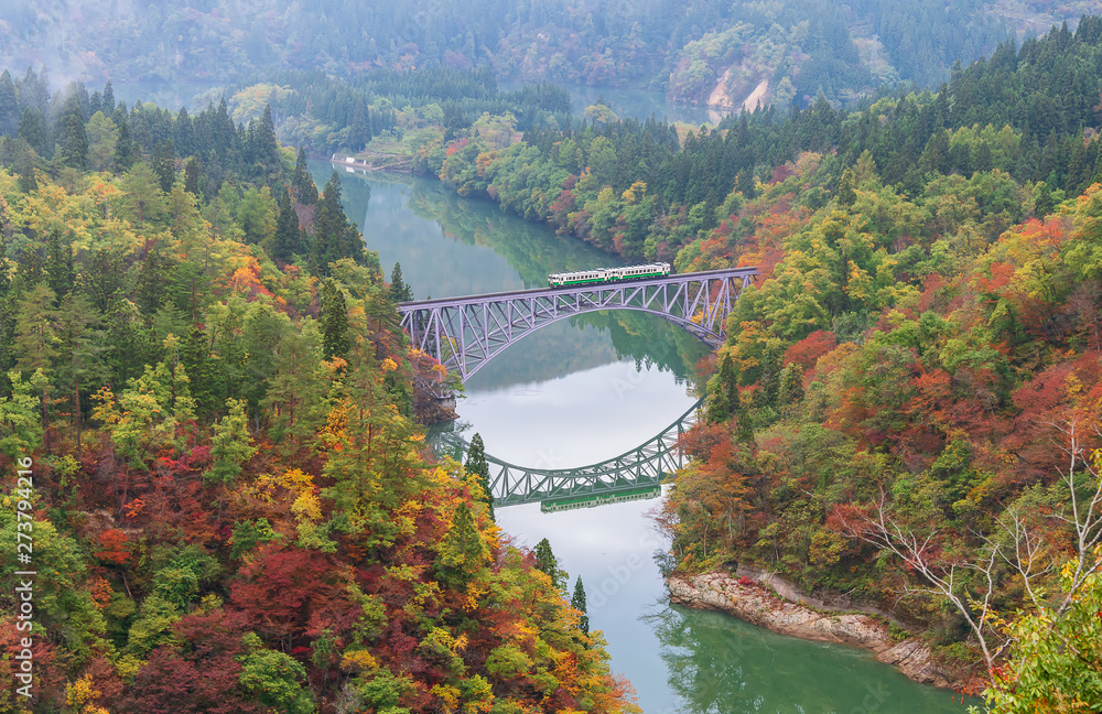 First bridge and Tadami river in beautiful autumn season with train crossing the bridge. First bridge and Tadami river in beautiful autumn season with train crossing the bridge.
