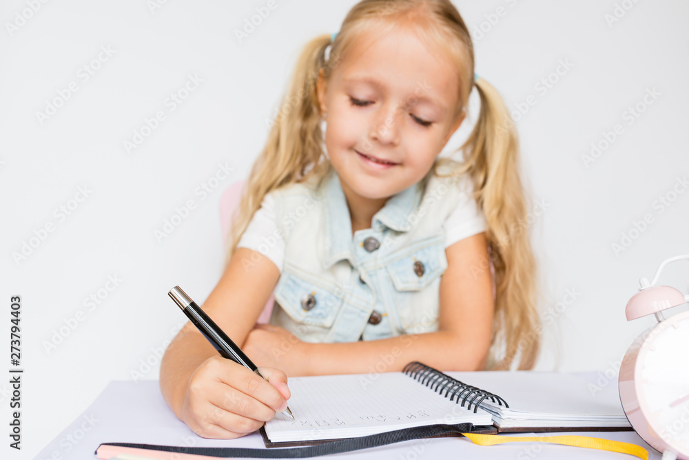 Back to school and happy time. Children holding pen and writting in notebook on white background. Kid making homework. Mockup, place for text, education concept