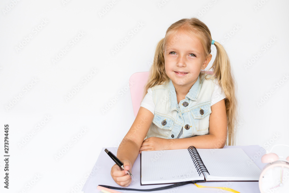 Back to school and happy time. Children holding pen and writting in notebook on white background. Kid making homework. Mockup, place for text, education concept Back to school and happy time. Children holding pen and writting in notebook on white background. Kid making homework. Mockup, place for text, education concept