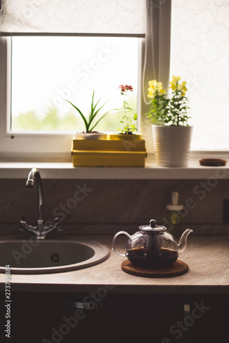kettle stands on the table in the kitchen summer home comfort flowers