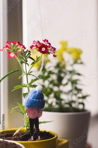 little toy girl in hat and flowers cozy