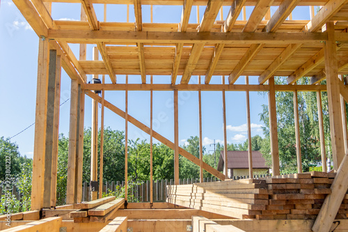 wooden interior frame of a new house under building, architectural residential construction stick built home framework.