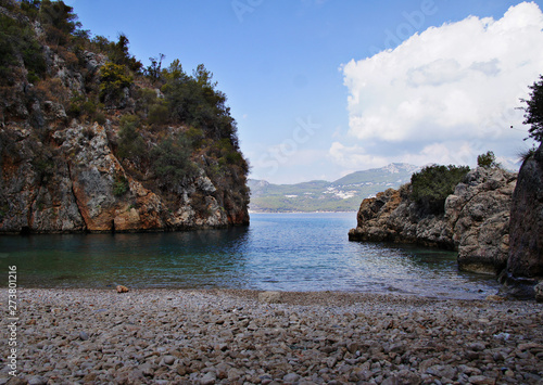 Seashore in Turkey. Summer beach with stones in the bay of the ocean.