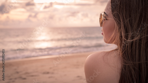 Young woman with sunglass on the beach at Sunset time in Thailand.summer travel concept with copy space for your Design.