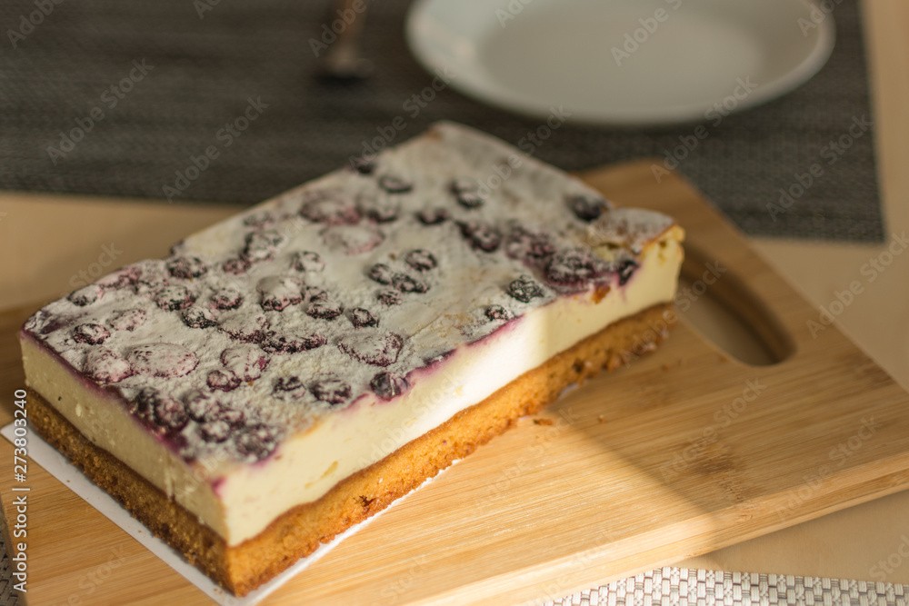 Cheesecake with fruits. Cake with cream and soft cheese on wooden board.
