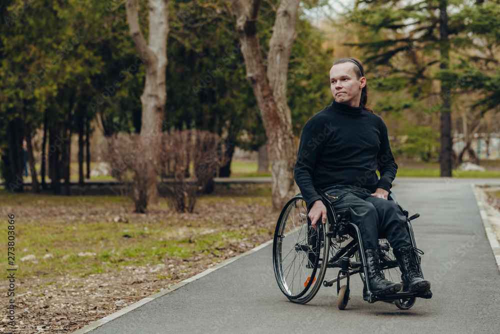 Portrait of a happy man on a wheelchair in a park