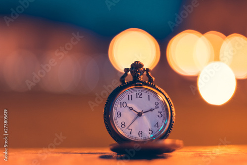 An old pocket watch photographed close to the blurred background