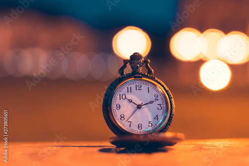 An old pocket watch photographed close to the blurred background