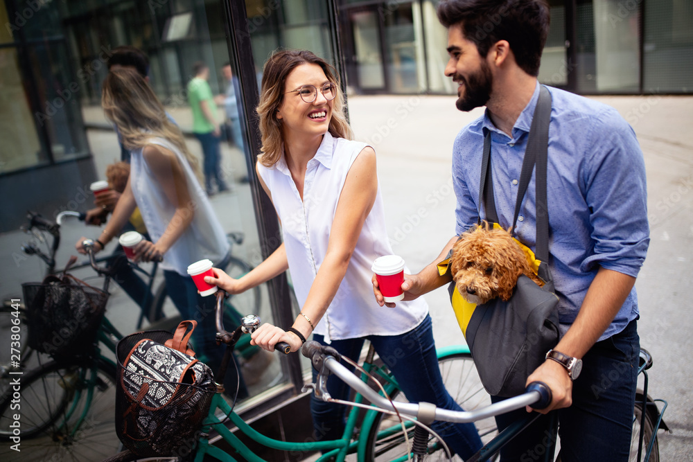 Beautiful couple walking dogs and bicycles outdoors in city Beautiful couple walking dogs and bicycles outdoors in city