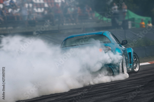Sport car in motion with a lot of smoke. Race car make a turn at high speed