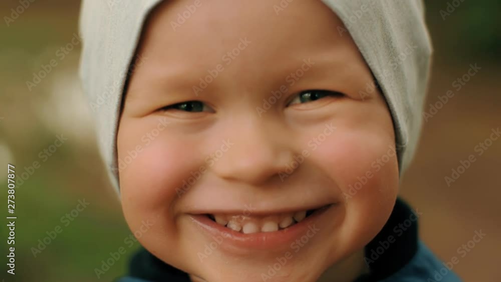 Close-up face of smiling cute little European baby boy posing looking at camera choker shot Close-up face of smiling cute little European baby boy posing looking at camera choker shot