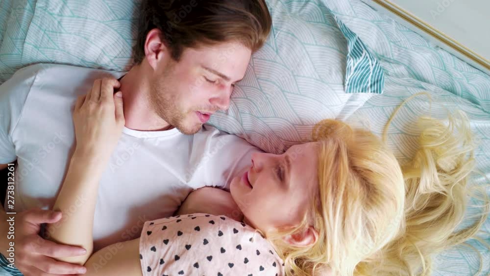 closeup rotating camera over two smiling lovers in bed in the morning closeup rotating camera over two smiling lovers in bed in the morning