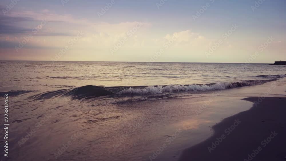 Blue ocean waves lapping over empty beach. Amazing sunset landscape. Slow motion footage. Steadicam. Blue ocean waves lapping over empty beach. Amazing sunset landscape. Slow motion footage. Steadicam.