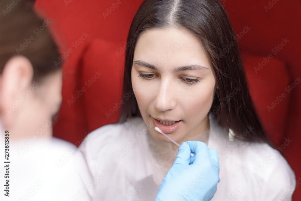moisturizing lips. the doctor wets the oral cavity with a cotton swab. dentistry, teeth whitening. moisturizing lips. the doctor wets the oral cavity with a cotton swab. dentistry, teeth whitening.
