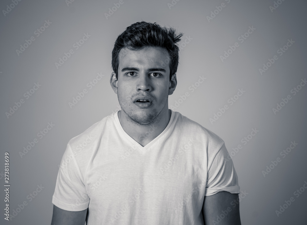 Fototapeta premium Natural portrait of young attractive man in his 20s looking and posing with neutral face expression