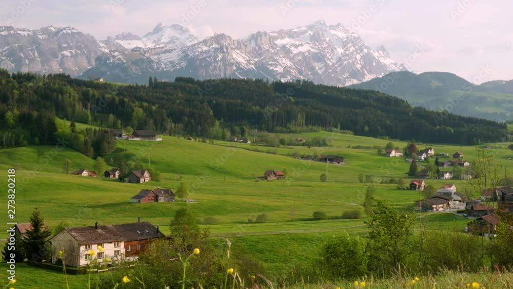 beautiful view of houses in the alps with amazing views of mountains and forests in the distance beautiful view of houses in the alps with amazing views of mountains and forests in the distance