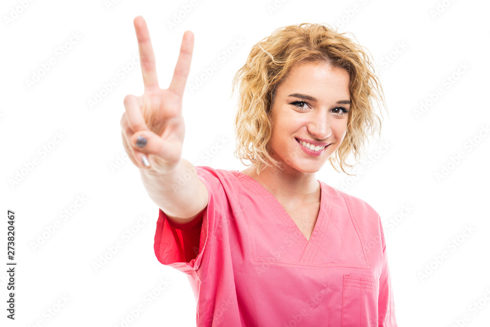 Portrait of young nurse wearing pink scrub showing peace gesture