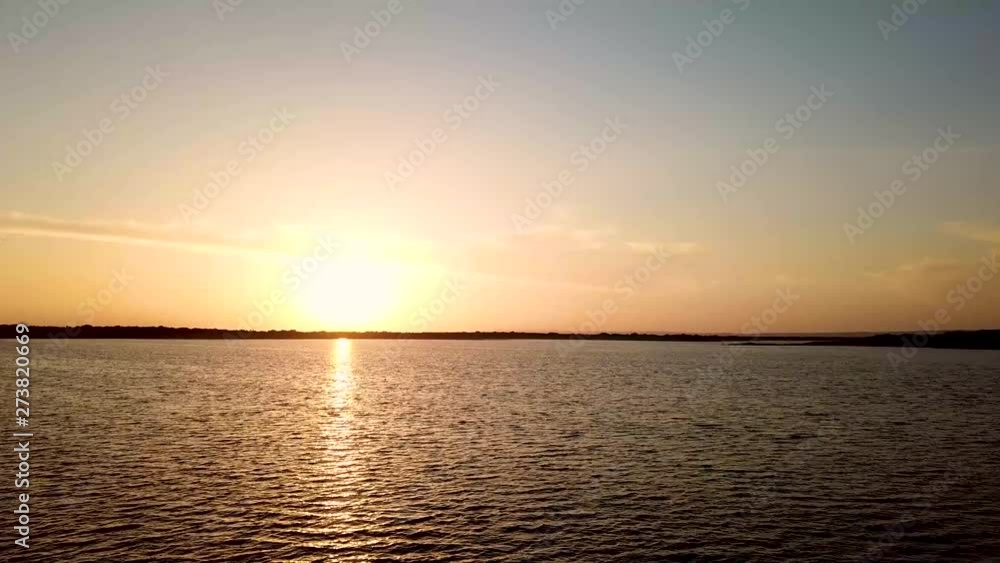Drone shot flying over lake towards sunset/sunrise Drone shot flying over lake towards sunset/sunrise