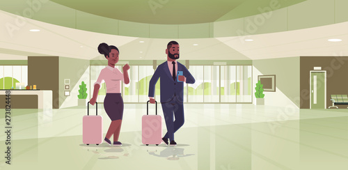 businesspeople with luggage couple standing at reception area african american business man woman holding suitcase contemporary lobby hotel hall interior flat horizontal full length