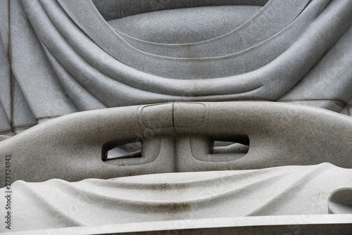 Closeup of sitting & peaceful giant Buddha statue inside Hill of the Buddha, Buddhist shrine at Makomanai Takino Cemetery, Sapporo, Hokkaido, Japan. Designed by Tadao, a Japanese modernist architect. photo