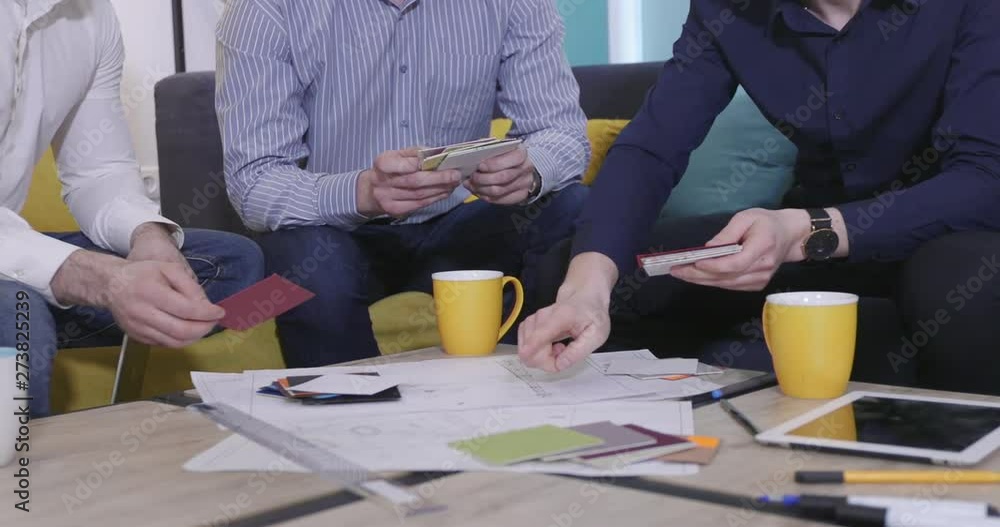 A group of businessmen are discussing a drawing. A group of businessmen are discussing a drawing.
