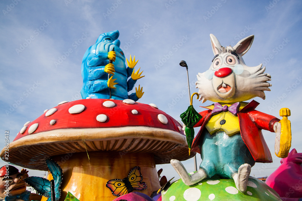 Fototapeta A caterpillar Absolem and white rabbit sitting on mushroom giant sculpture from Alice in wonderland on a carnival parade