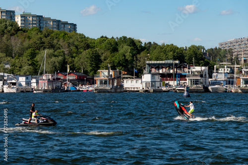 Photography Stockholm, Sweden Jet skis in the lake in front of houseboats in the Solna suburb and Pampas Marina on a summer day
